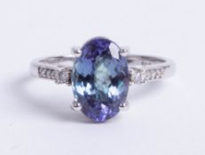 An 14k tanzanite and diamond mixed colour ring, size N.