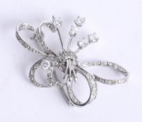An unmarked probably 18ct white gold diamond ribbon spray brooch, length 39mm.