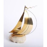 A contemporary gilt model of a sailing yacht on marble base, signed, height 25cm.