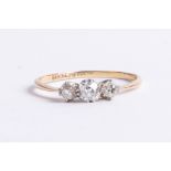 An 18ct diamond three stone ring, size V.