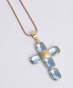 An aquamarine and yellow gold cross on a chain, 13.8g.