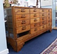 A vintage oak haberdashery cabinet fitted with 19 drawers (one missing), length 178cm, height