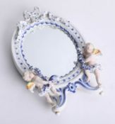 A blue and white porcelain wall mirror surmounted with cherubs, height 31cm.