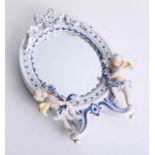 A blue and white porcelain wall mirror surmounted with cherubs, height 31cm.