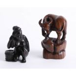 Two Japanese dark wood netsukes, one depicting a woman washing her back and one depicting a horned