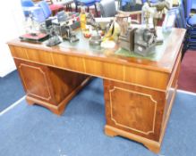 A leather topped two pedestal desk fitted with nine drawers, height 76cm and width 150cm, also