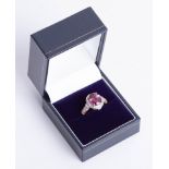 An 18ct rose gold umbalite garnet and diamond cluster ring set with further diamonds to the