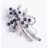 A diamond and sapphire brooch in white metal.