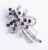 A diamond and sapphire brooch in white metal.