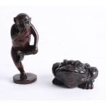 Two Japanese dark wood netsukes, one depicting a toad and the other depicting a monkey on one leg.