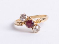 An 18ct ruby and diamond three stone ring, size R.