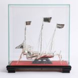 A 20th century white metal Chinese boat in glass case, possibly Wang Hing.