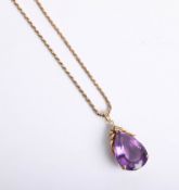 An amethyst and diamond pear drop pendant set in gold on a gold chain marked 14k.