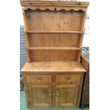 SMALL PINE DRESSER WITH TWO PLATE RACKS TO TOP AND TWO DRAWERS OVER TWO CUPBOARD DOORS