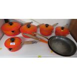 SIX PIECES OF LE CREUSET CAST IRON ORANGE COOKWARE AND ONE SIMILAR EXAMPLE