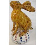 David Cleverly studio pottery figure of a hare in treacle glaze on a domed base painted with red and