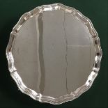 A circular silver piecrust tray raised on four hoof feet, marks for Sheffield, 1939, maker's stamp