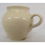 A Dennis Chinaworks plain cream pottery mug of ovoid shape, impressed factory mark and initials,