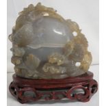 Carved figural group of two dragons entwined around egg with foliage, pale grey stone perhaps agate,