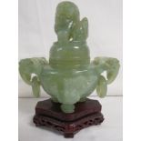 Carved jade jar with two elephant mask handles with rings raised on three feet, the lid carved