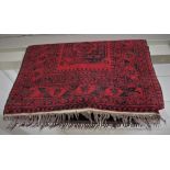 RED GROUND RECTANGULAR FLOOR RUG, WITH CENTRAL MEDALLION AND TASSELED ENDS