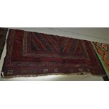 RED GROUND PATTERNED GAZAK RUG WITH TASSELED ENDS, 119CM BY 123CM
