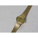LADIES TISSOT MECHANICAL WRISTWATCH WITH OVAL DIAL AND BATON NUMERALS, WITH 9 CARAT GOLD TEXTURED