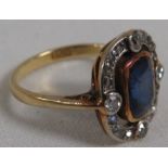 18 carat gold ring set with a sapphire surrounded by four small diamonds (each estimated at 0.06