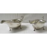 A pair of silver sauce boats, each on three hoof feet with scrolled handles, marks for Birmingham,