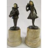 A pair of bronze figures of Pierrot and Columbine with resin faces mounted on marble socles, overall