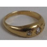 Gold ring set with three graduated diamonds in flush setting, (the largest stone estimated at 0.25