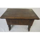 Oak stool with hinged seat, the front panel carved with two fans, standing on sectional end feet, (