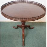 An early 19th century circular mahogany galleried tilt-top table. The spiral single pedestal has