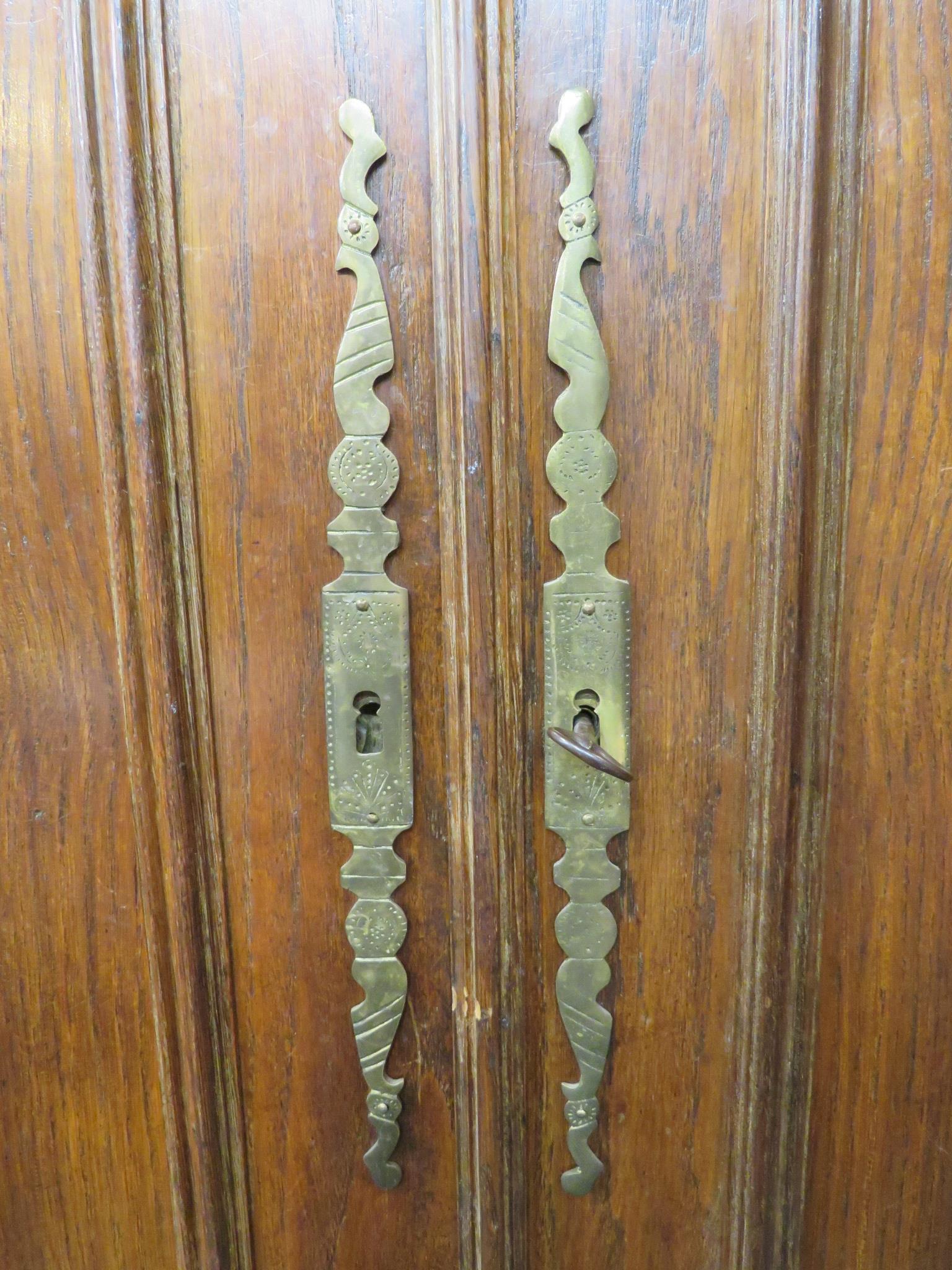An early 19th century tall French oak armoire, two arch topped doors with long tooled brass - Image 5 of 7