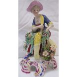 Chelsea style porcelain figure of a seated lady with flowers and wheat, on an oval scrolled base