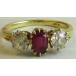 Yellow metal ring set with a central ruby between two diamonds, the oval ruby 5mm x 4mm, the