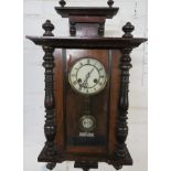 A Victorian eight day chiming wall clock in an ebonised and mahogany case. The glazed door is