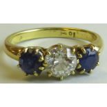 Yellow metal ring set with a diamond between two sapphires, the brilliant cut diamond estimated at