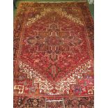 Middle Eastern large red ground patterned carpet, (4.05m x 3m), labelled "100% wool Heriz hand woven