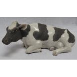 Raku pottery model of a recumbent cow, height 13cm, length 31.5cm