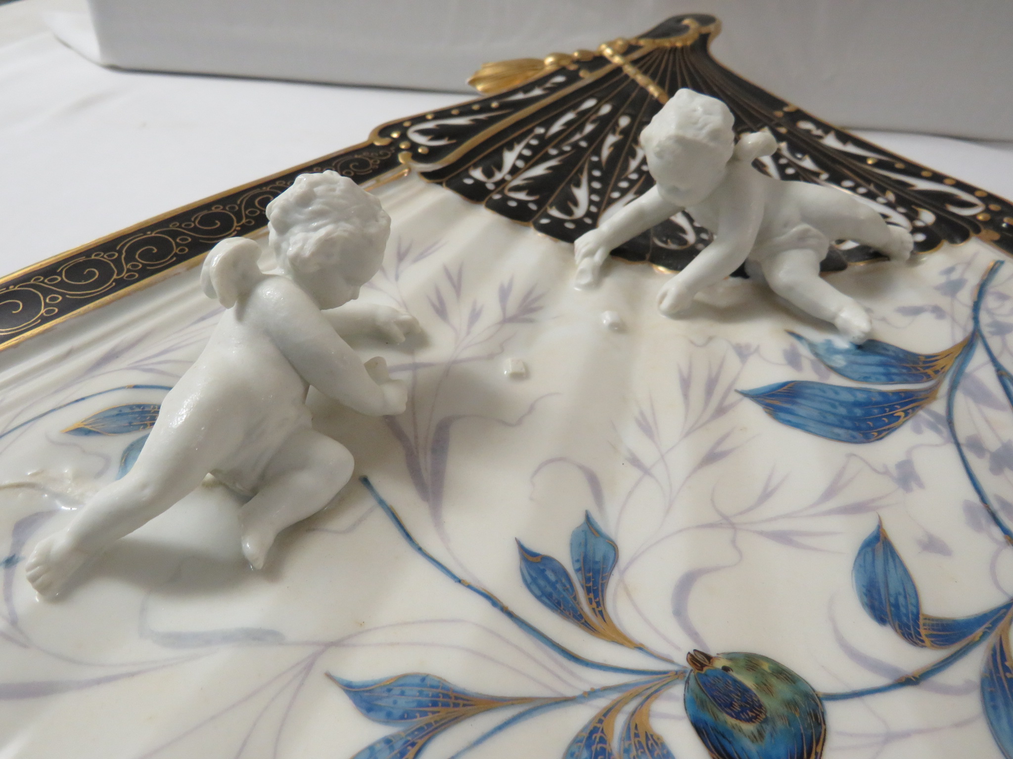 Porcelain wall plaque modelled as a fan with two moulded cherubs, black enamel and gilding and - Image 2 of 6