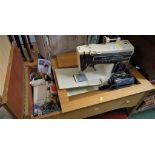 SINGER ELECTRIC SEWING MACHINE (NEEDS PLUG) SET IN WOOD VENEERED TABLE WITH CONTENTS