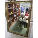 RECTANGULAR WALL MIRROR IN A GILT EFFECT FRAME MOULDED WITH SCALLOPS AND LEAVES