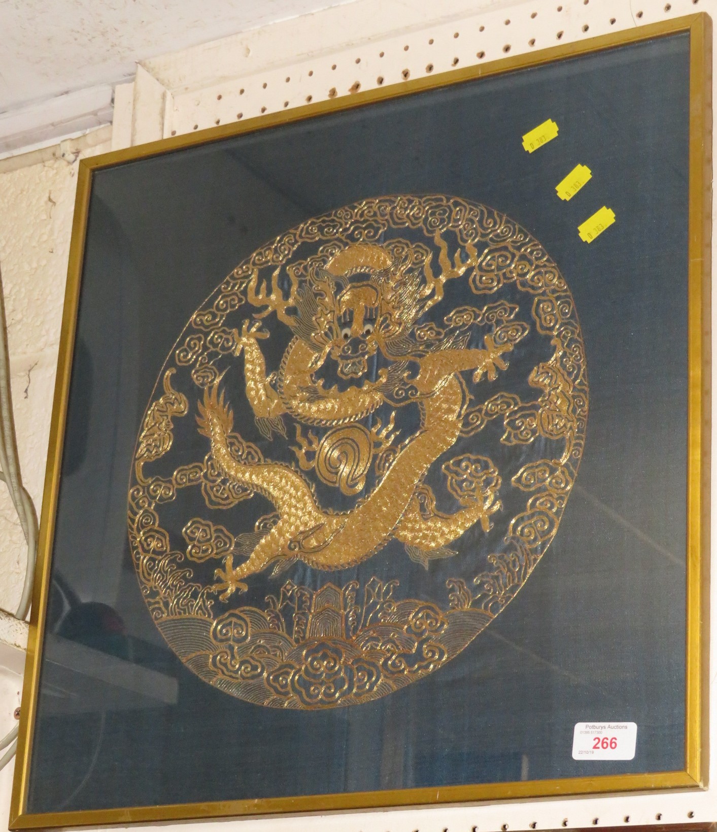 FRAMED AND GLAZED EMBROIDERY IN GOLD COLOURED THREAD DEPICTING CHINESE DRAGON WITH STYLIZED CLOUDS