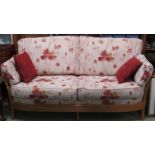 ERCOL RENAISSANCE LIGHT ELM FRAMED TWO-SEATER SETTEE WITH PALE UPHOLSTERY PATTERNED WITH RED AND