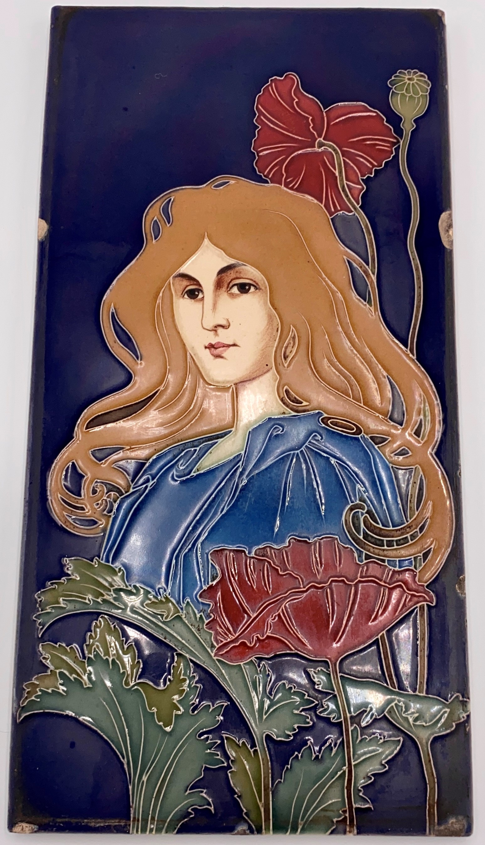 An Art Nouveau ceramic tile by Carl Sigmund Luber, depicting head and shoulders of woman in blue