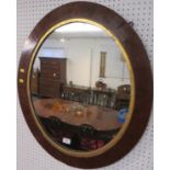 Oval wall mirror in mahogany frame with an inner gilded margin and ebony and boxwood feather