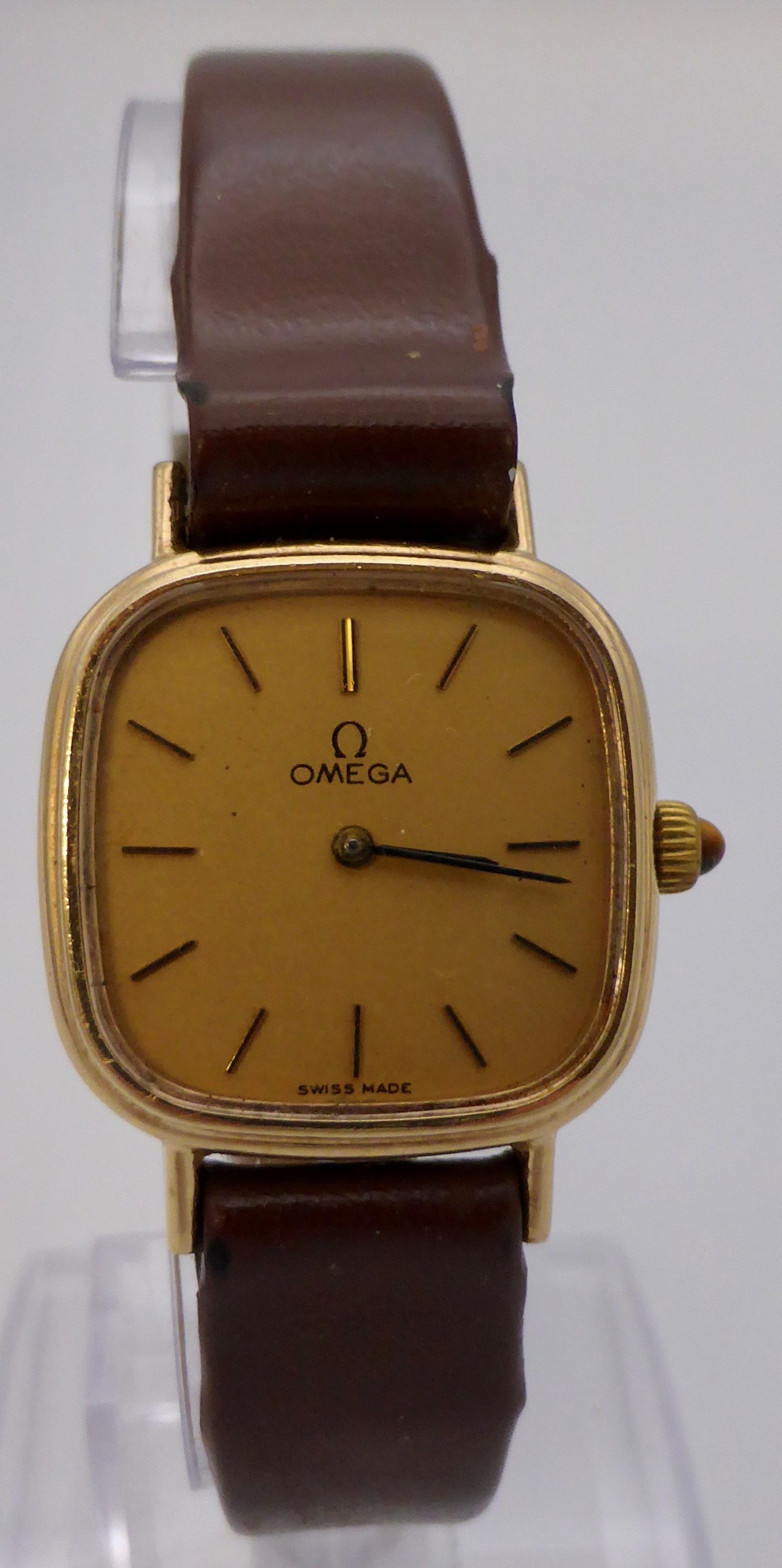 9 carat gold Omega lady's mechanical wristwatch with brown leather strap, oblong champagne dial,
