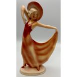 German Art Deco "Katshute" ceramic figure of woman in hat holding hem of pink dress, on oblong base,