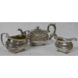 A matched three-part silver tea set comprising a George III silver teapot with acanthus moulded